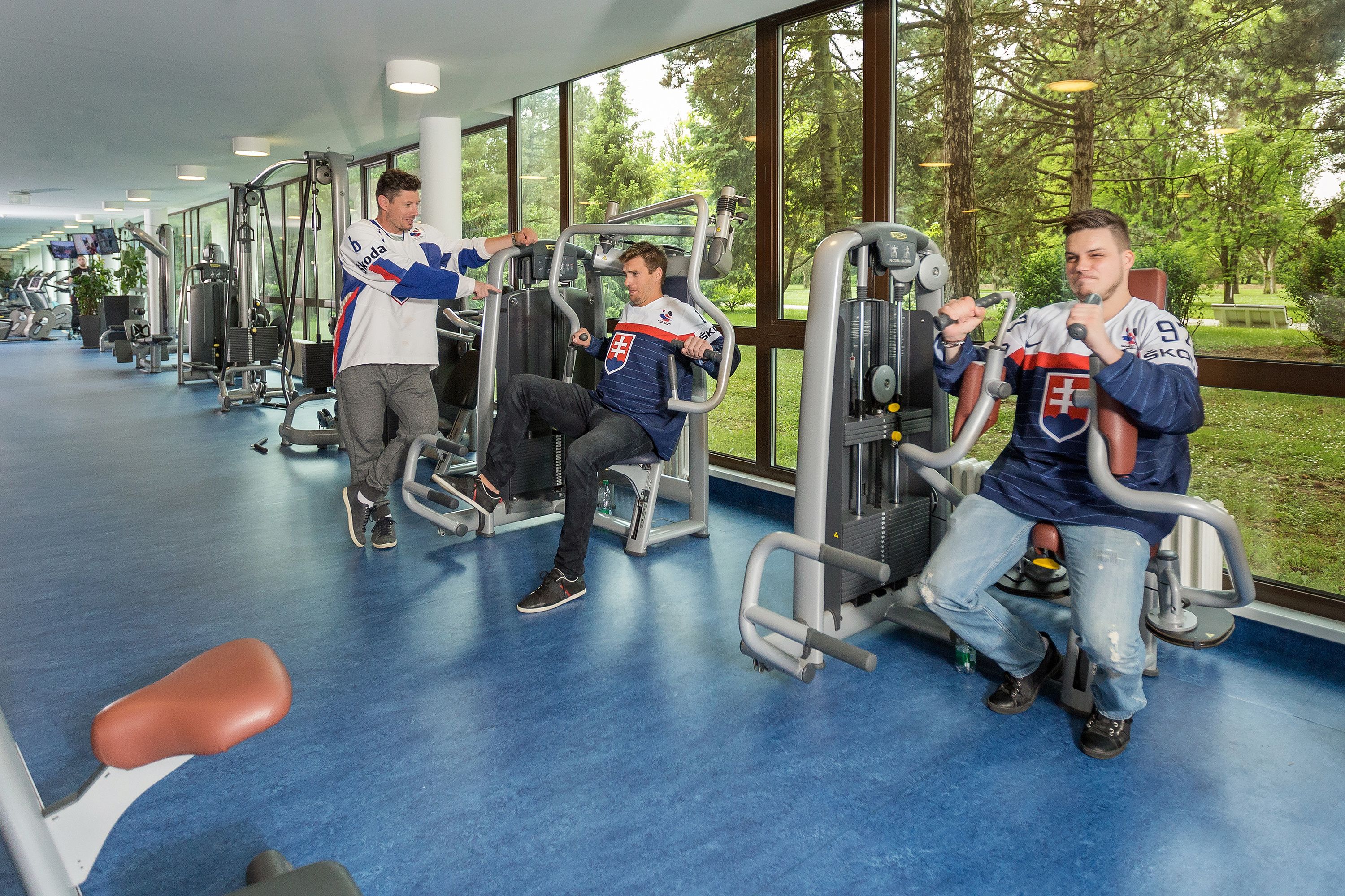 A gym with exercise equipment and large windows.