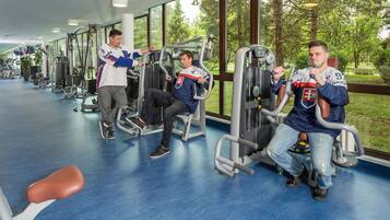 A gym with exercise equipment and large windows.