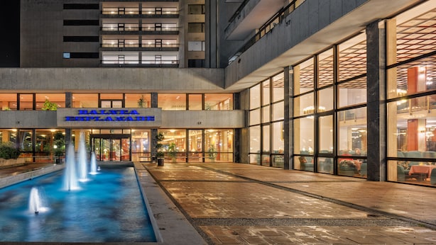 Een hotel met een zwembad, terras en een bord met de tekst 'BAILEY ESPALDA'.