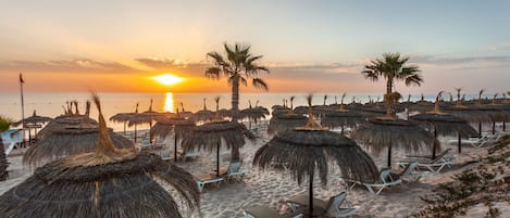 Aan een privéstrand, ligstoelen, parasols