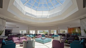 A spacious lobby with a high ceiling and a skylight, featuring multiple seating areas and a large central sofa. - El Mouradi Club El Kantaoui (Port El Kantaoui)