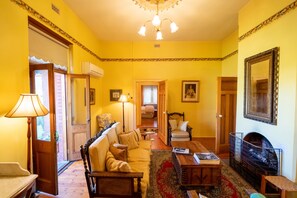 Un salon chaleureux avec un canapé, des fauteuils, une table basse et une cheminée.