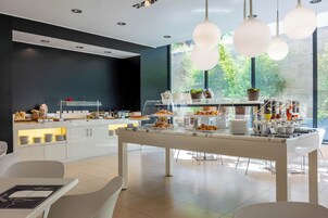 Un'area colazione moderna con un'attrezzatura tipo buffet, che offre una varietà di cibi e una postazione per il caffè.