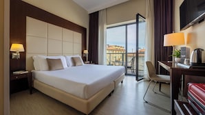 A hotel room with a large bed, a desk with a chair, a TV, and a balcony with a view. - iH Hotels Milano Watt 13 (Milan)