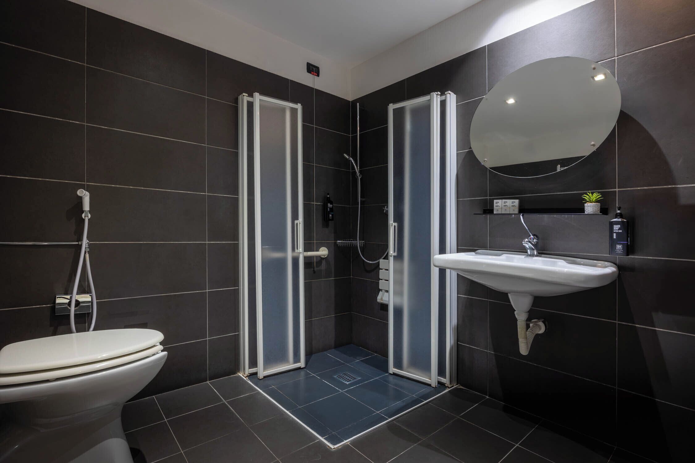 A modern bathroom with a toilet, a glass-enclosed shower, and a sink.