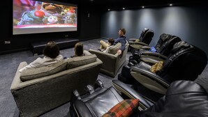 A home theater with reclining chairs and a large screen. - Cork International Hotel (Cork)