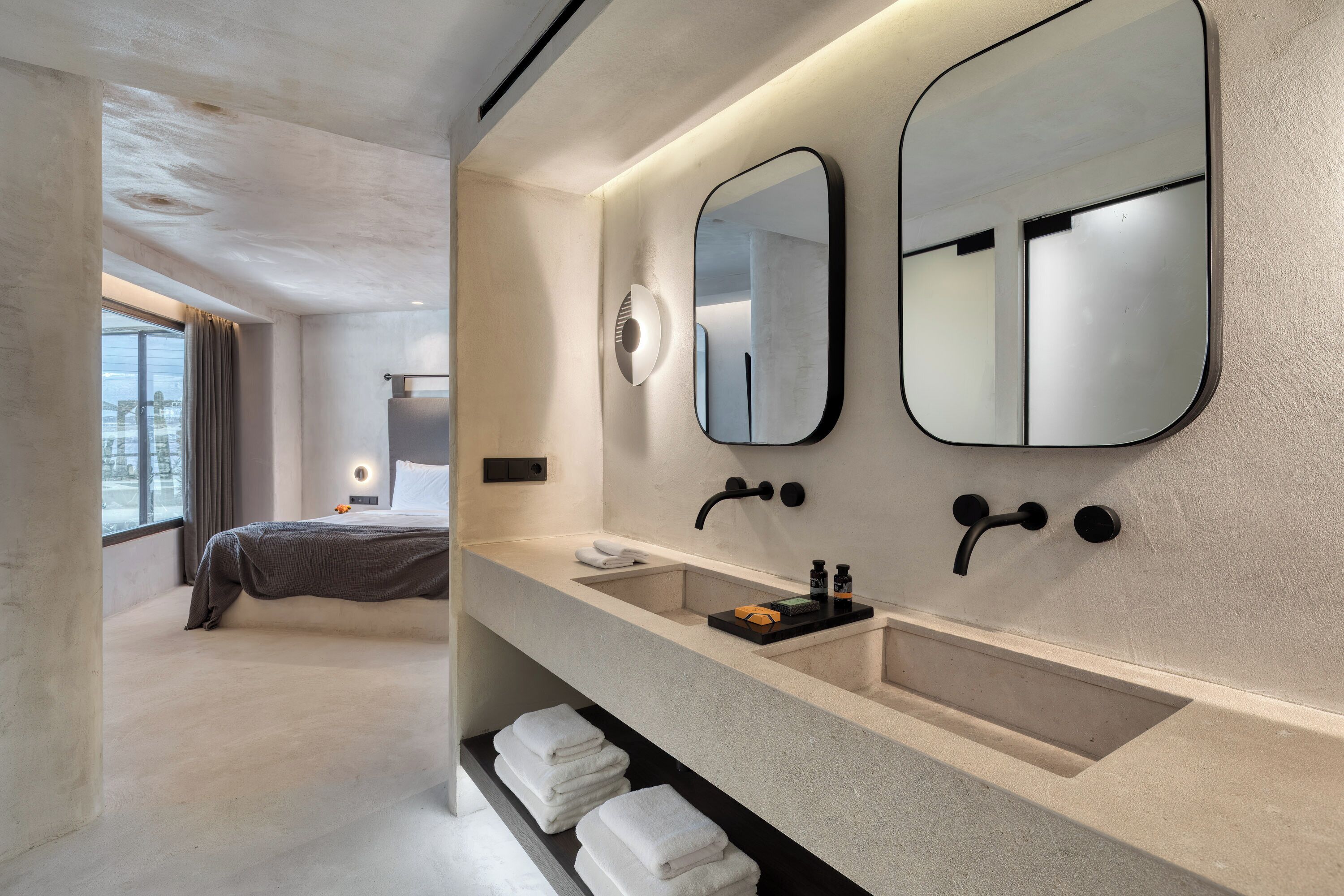 Ein modernes Badezimmer mit großem Spiegel, Waschbecken und Handtuchhalter.