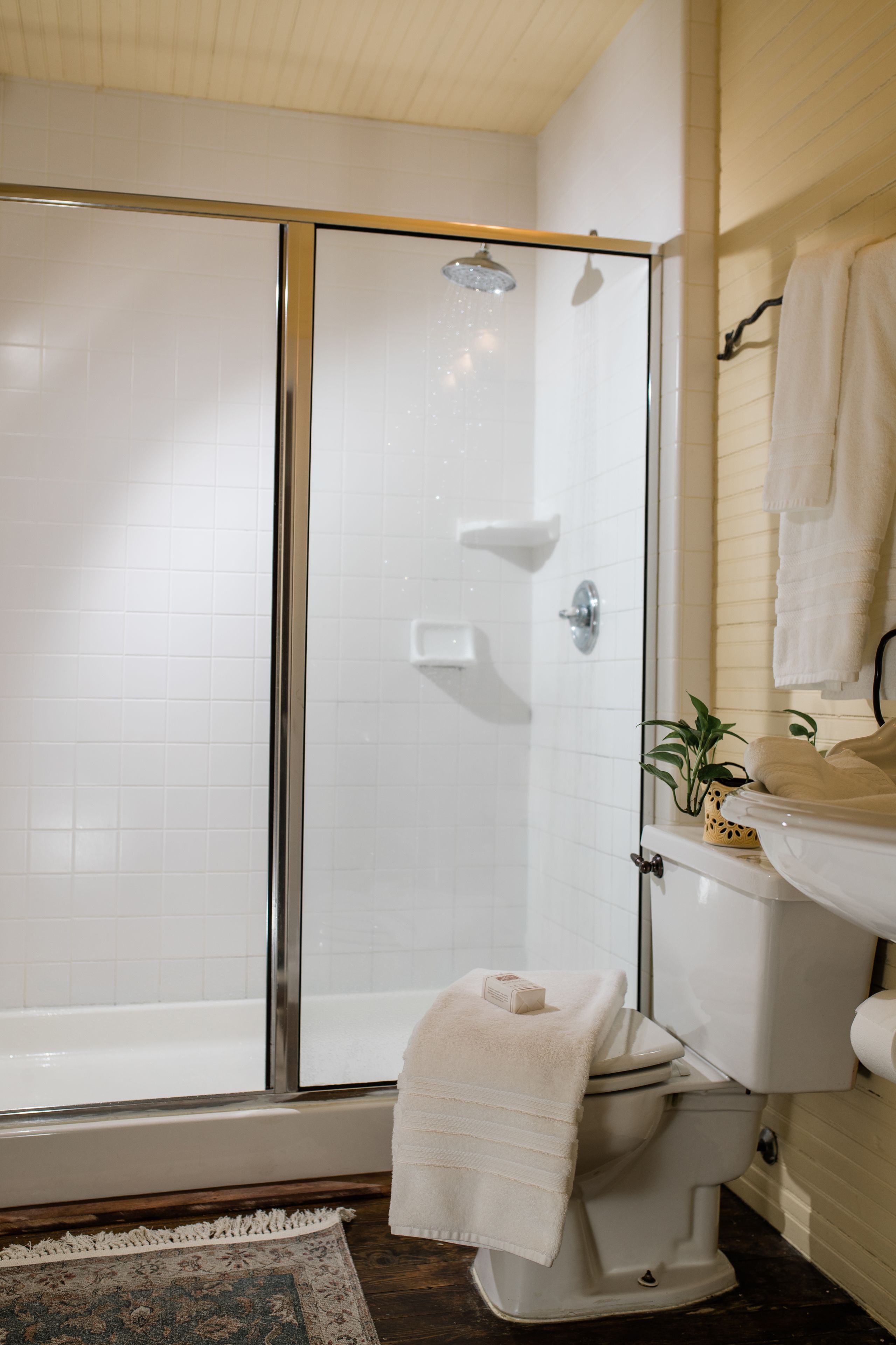 Ein Badezimmer mit Duschkabine, Toilette, Waschbecken und Spiegel.