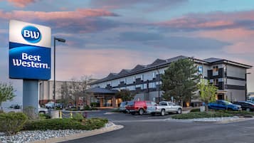 Et Best Western hotel med en moderne bygning, en parkeringsplads og flere biler foran.