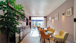 Een modern interieur met een keukenhoek, eettafels en een grote potplant.