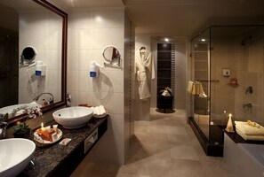 Executive suite | Badkamer | Een bad/douchecombinatie, een haardroger, badjassen, handdoeken