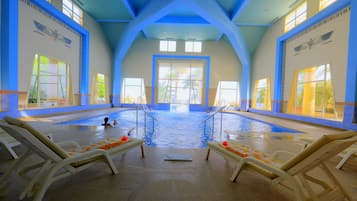 Relax by the pool surrounded by comfortable lounge chairs and large windows.