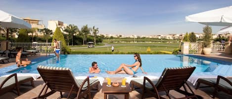 Piscine extérieure, parasols de plage, chaises longues