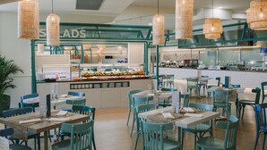 A restaurant with teal chairs and tables, a buffet area, and hanging wicker lamps. - Suites & Villas by Dunas (San Bartolomé de Tirajana)