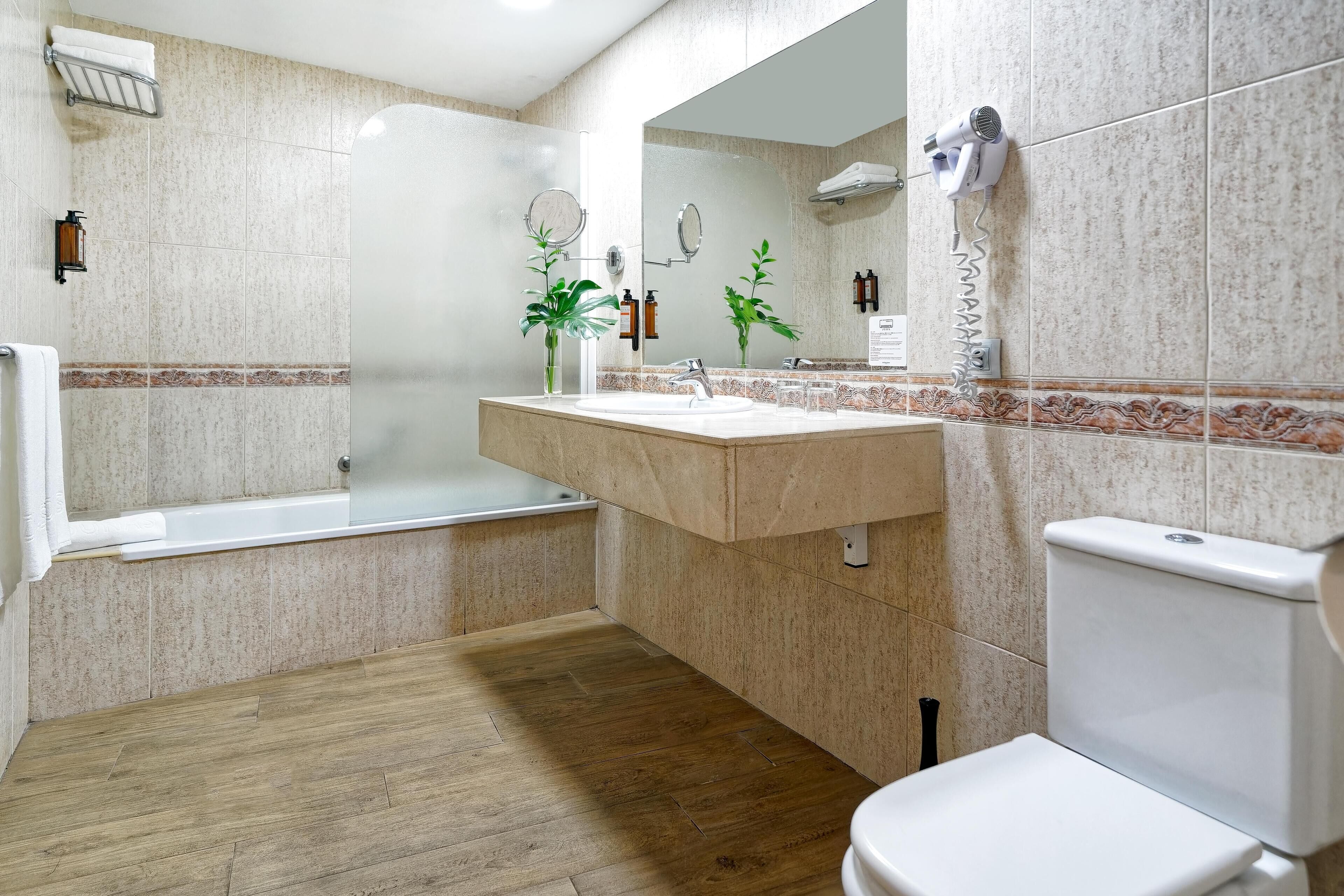 A modern bathroom with a bathtub, sink, and toilet.