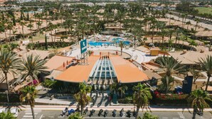 A resort with a central pool, palm trees, and a view of distant mountains. - Suites & Villas by Dunas (San Bartolomé de Tirajana)
