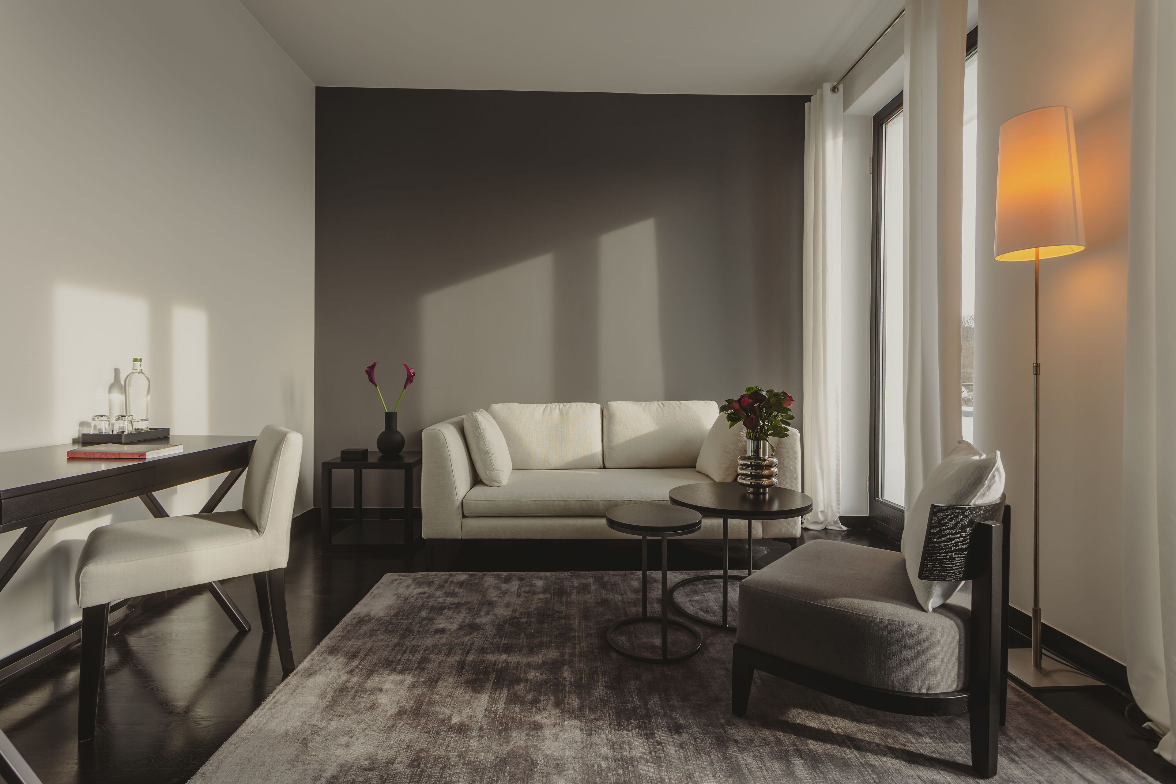 Una sala de estar moderna con un sofá, una mesa de centro, una silla y un escritorio.