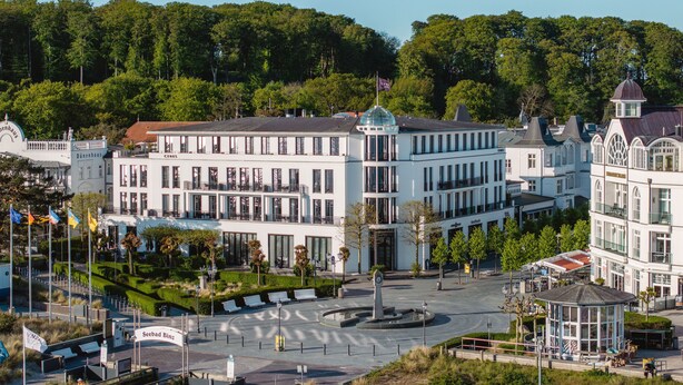 Un grand bâtiment blanc, doté de plusieurs étages et d’une cour intérieure.