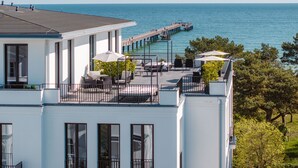 Un bâtiment moderne doté d’un patio sur le toit offrant une vue sur une mer paisible.