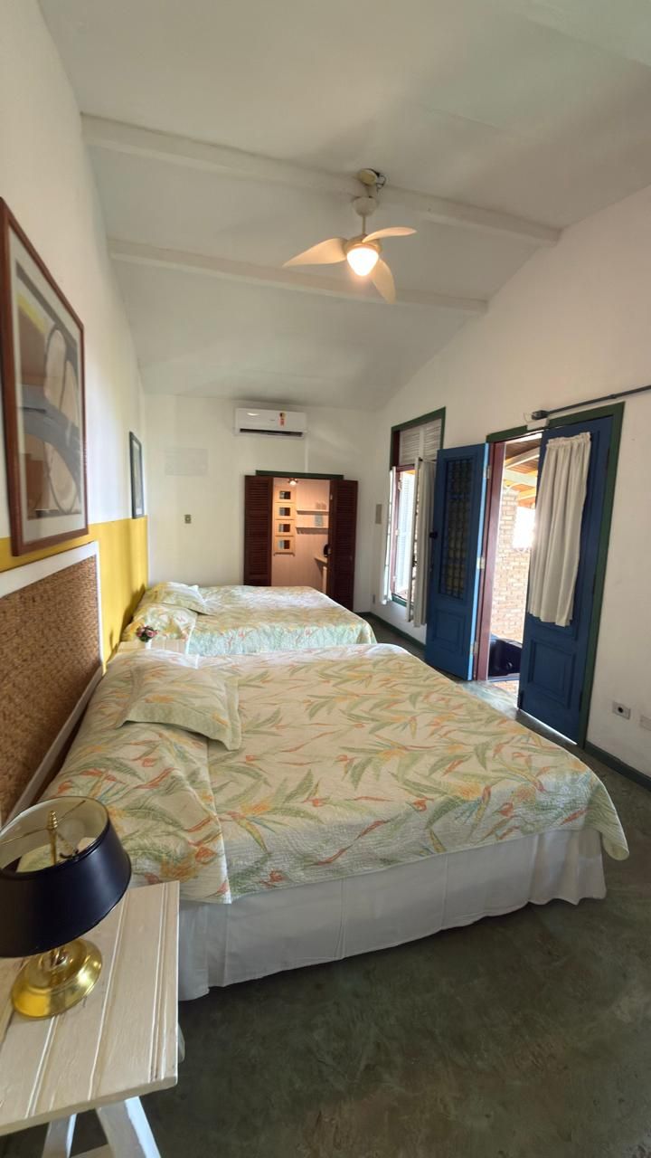 A bedroom with two beds, a ceiling fan, and a desk with a lamp.