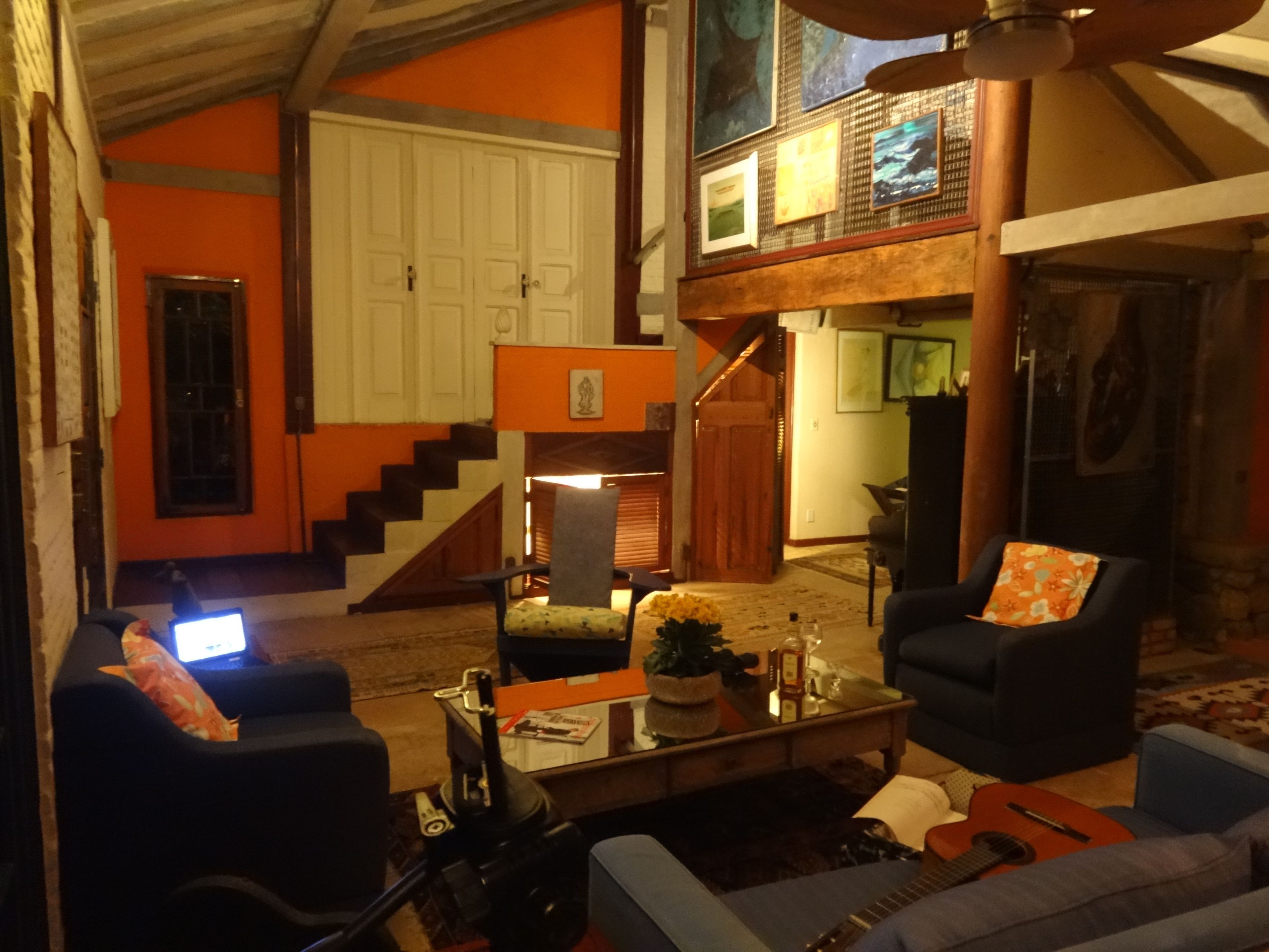 Un salón comedor amplio con techo alto, una escalera y un ventanal grande.