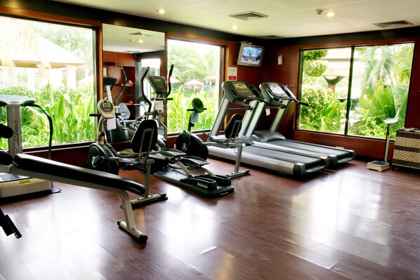 A gym with treadmills, elliptical machines, and weight equipment.