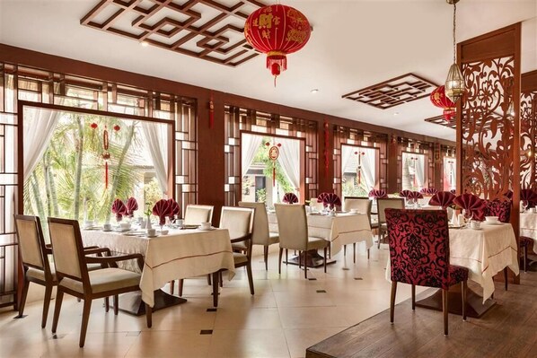 Un restaurante con mobiliario de madera, faroles rojos y amplias ventanas.