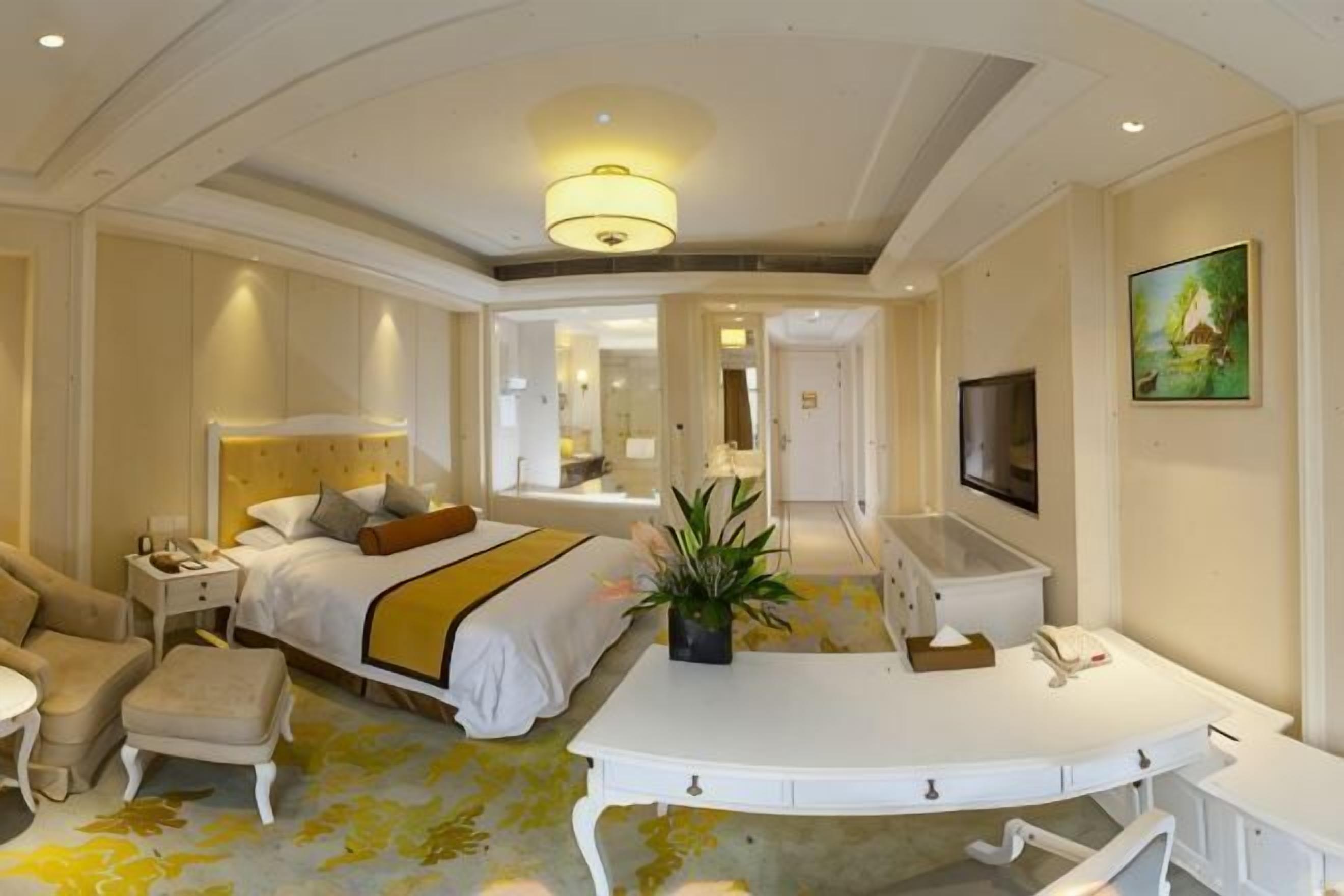 Une chambre d’hôtel comprenant un lit, une table de chevet, une chaise, un bureau et un miroir.