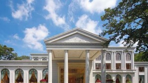A grand building with a symmetrical facade, large columns, and arched windows. - Dongjiao State Guesthouse (Nanjing)