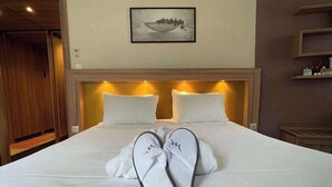 A neatly made bed with white linens, a headboard with built-in lighting, and a framed picture on the wall. - Hotel Mercure Libourne Saint-Emilion (Libourne)