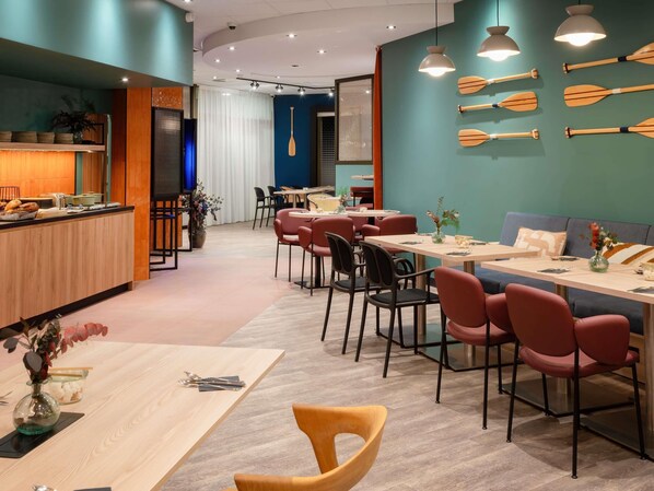 A modern restaurant with wooden tables and chairs, a bar area, and decorative wooden oars on the wall.