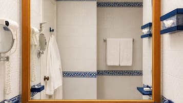 Ein Badezimmer mit einem großen Spiegel, einem weißen Waschbecken und blauen Fliesen mit Muster.