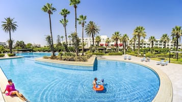 Een binnenzwembad, een buitenzwembad, parasols voor strand/zwembad