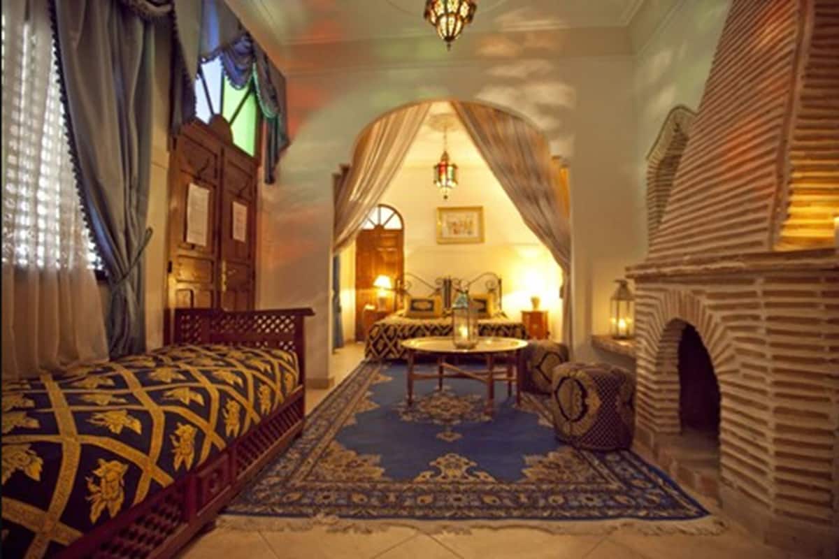 Une chambre traditionnelle avec un lit, une table à manger et une cheminée.