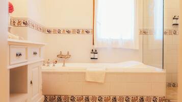 Une salle de bain avec une baignoire, un lavabo et un miroir.
