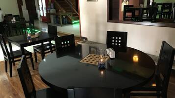 A dining area with a round table, black chairs, and a bottle of Coca-Cola.