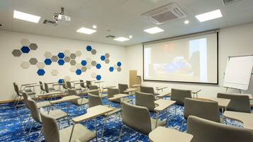 A conference room with hexagonal wall decor, a projector, and a whiteboard.