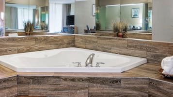 Une salle de bain moderne avec une grande baignoire sur pieds, des panneaux muraux en bois et un grand miroir qui reflète la pièce.