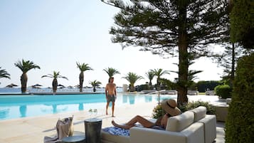 Una piscina techada, una piscina al aire libre de temporada, sombrillas