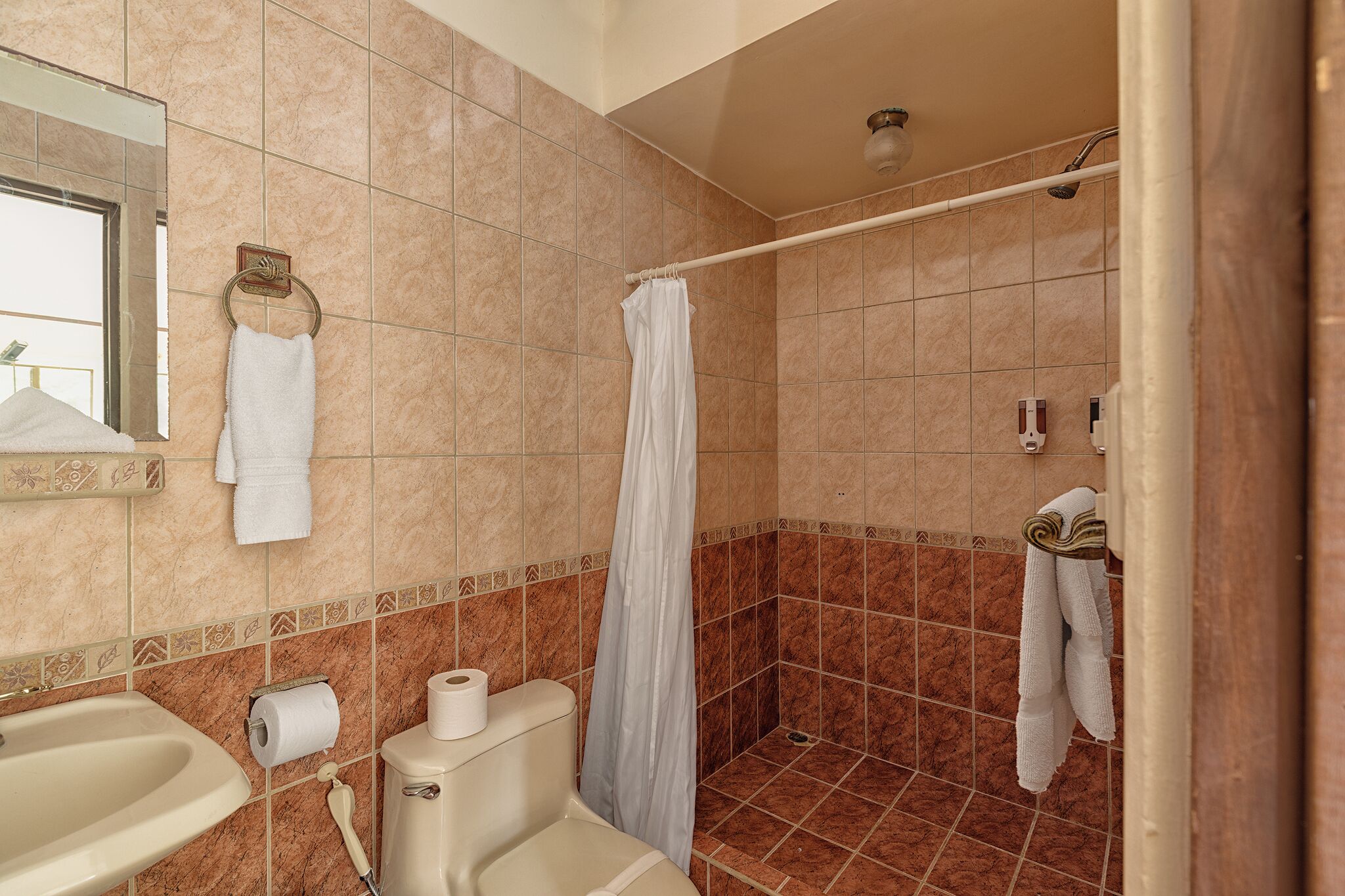 A bathroom with a bathtub, a toilet, a sink, and a shower curtain.