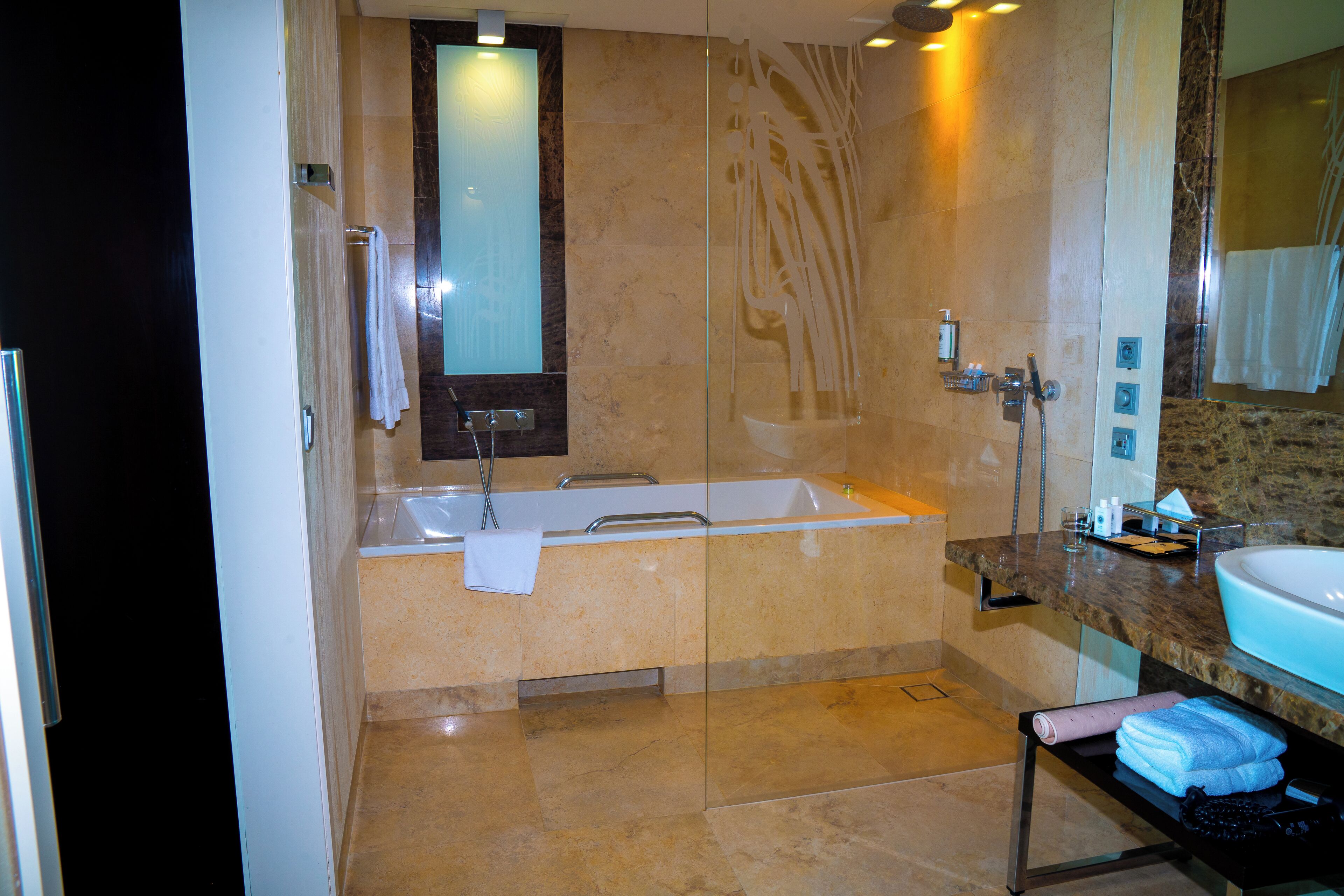 A modern bathroom with a glass-enclosed shower, a freestanding bathtub, and a vanity with a sink and mirror.