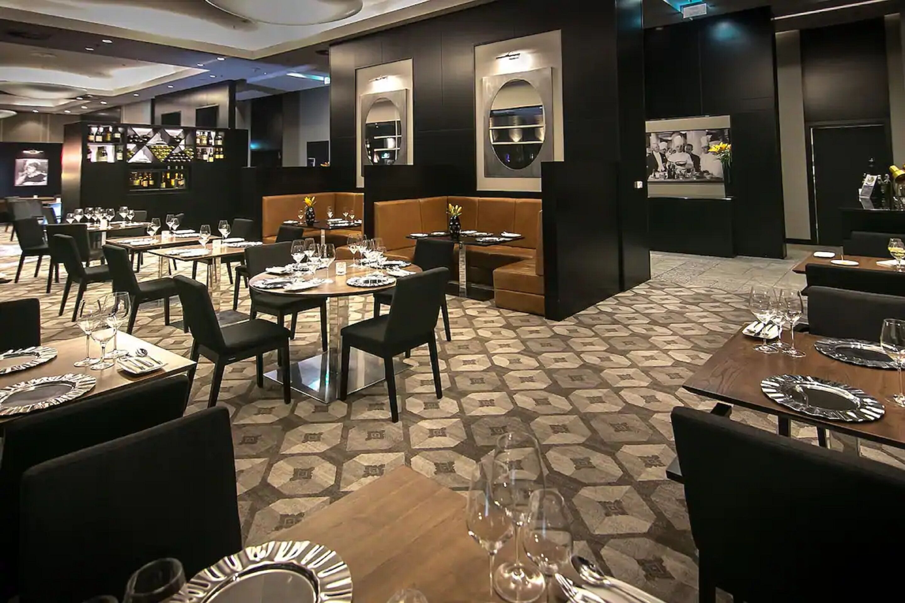 Un restaurante con varias mesas y cabinas, cada una dispuesta con platos, vasos y cubiertos.