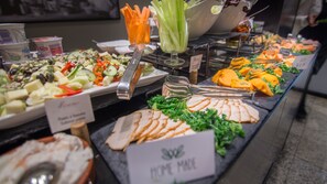 A buffet with various food items including salads, fruits, and vegetables.