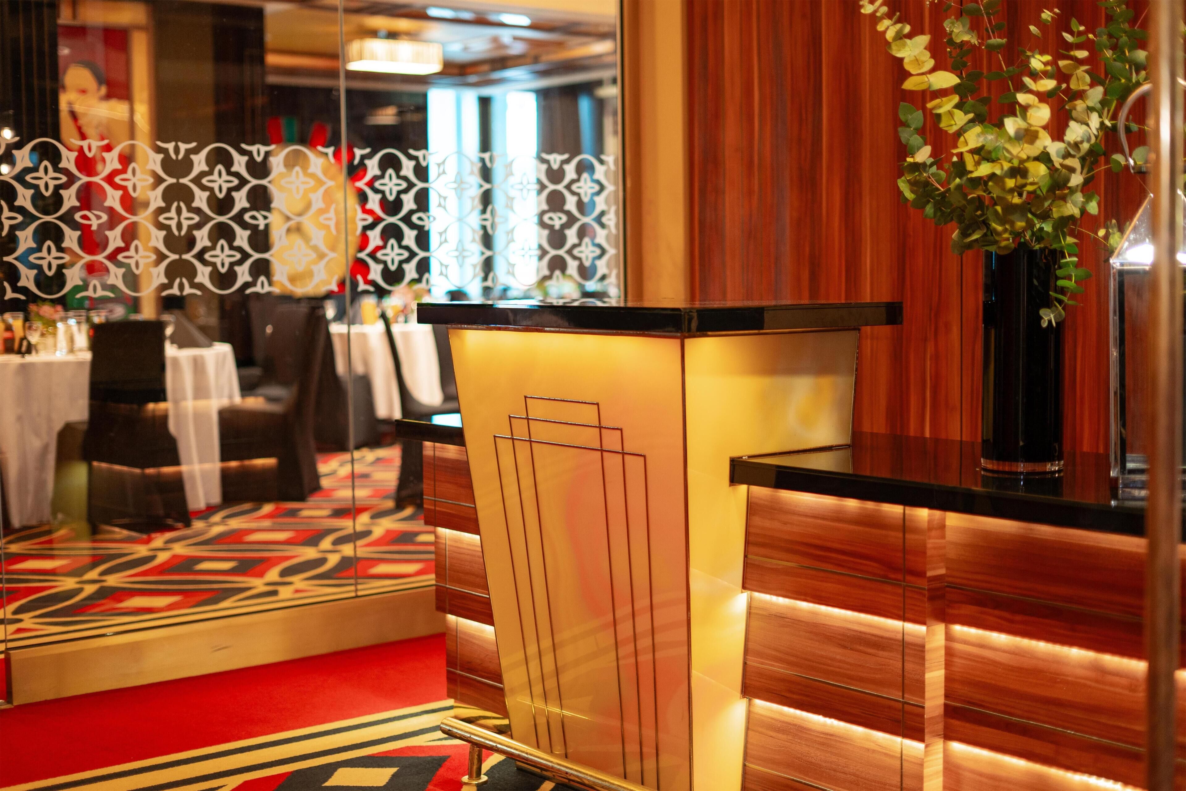 A hotel reception area with a modern design, including a reception desk, seating area, and decorative elements.