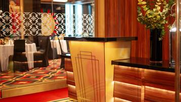 A hotel reception area with a modern design, including a reception desk, seating area, and decorative elements.