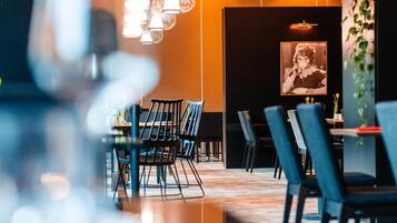Un comedor moderno con lámparas colgantes, una pared con una pizarra y un cuadro enmarcado.