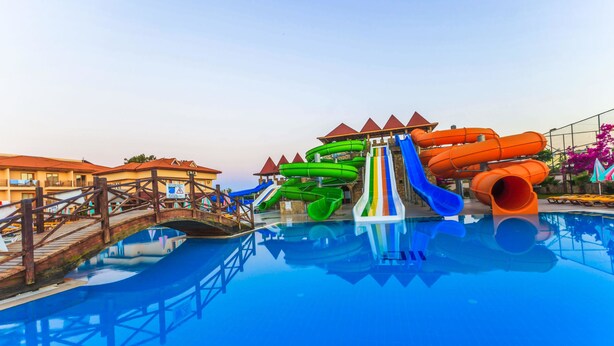A water park with multiple slides and a bridge over a pool. - Eftalia Village Hotel - All Inclusive (Alanya)