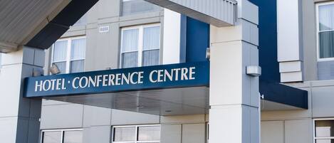 Un bâtiment moderne avec une enseigne bien visible indiquant « Cambridge Hotel » et « Centre de conférences ».