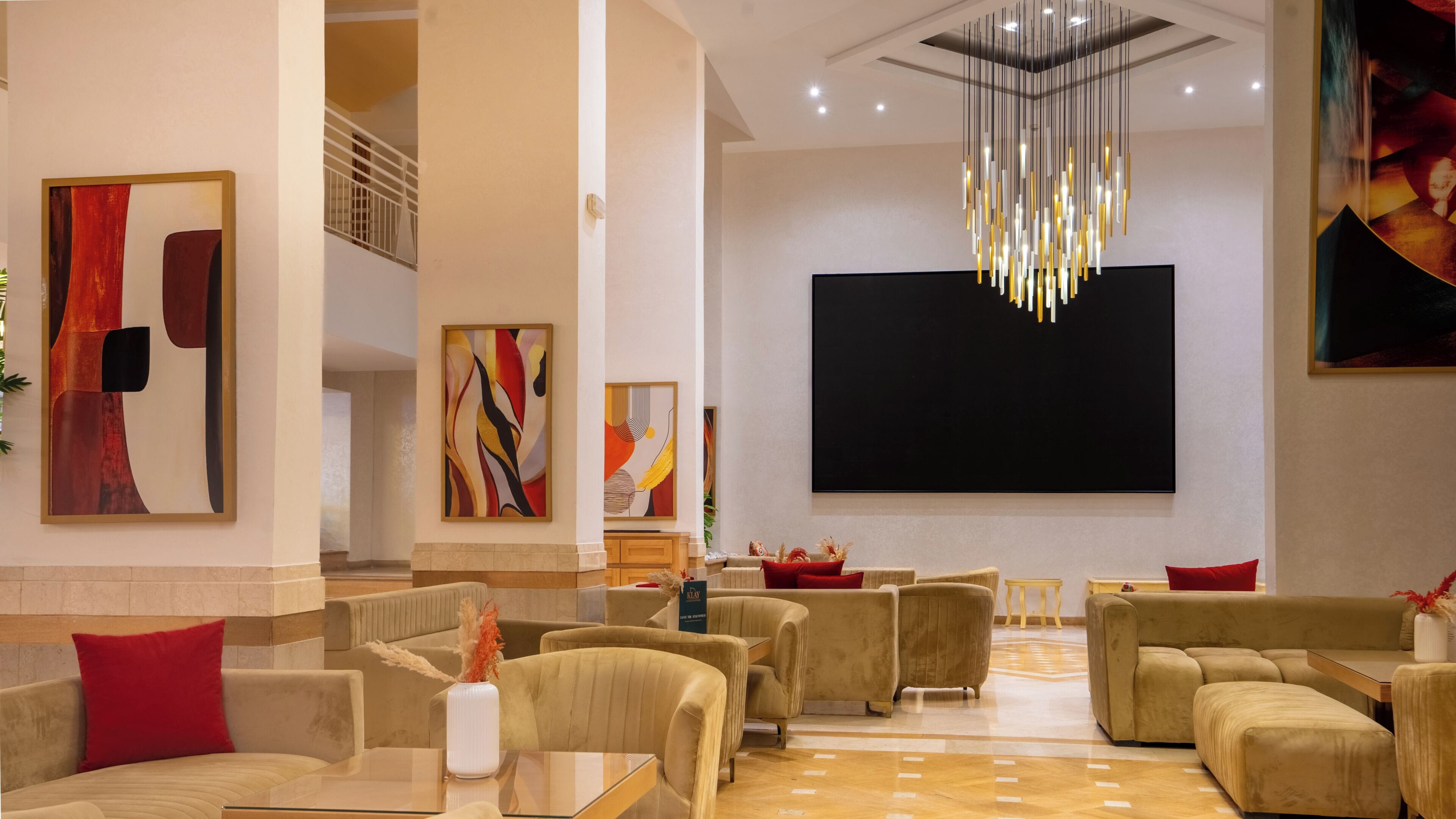 A spacious lobby with modern furniture, a large flat-screen TV, and contemporary artwork.