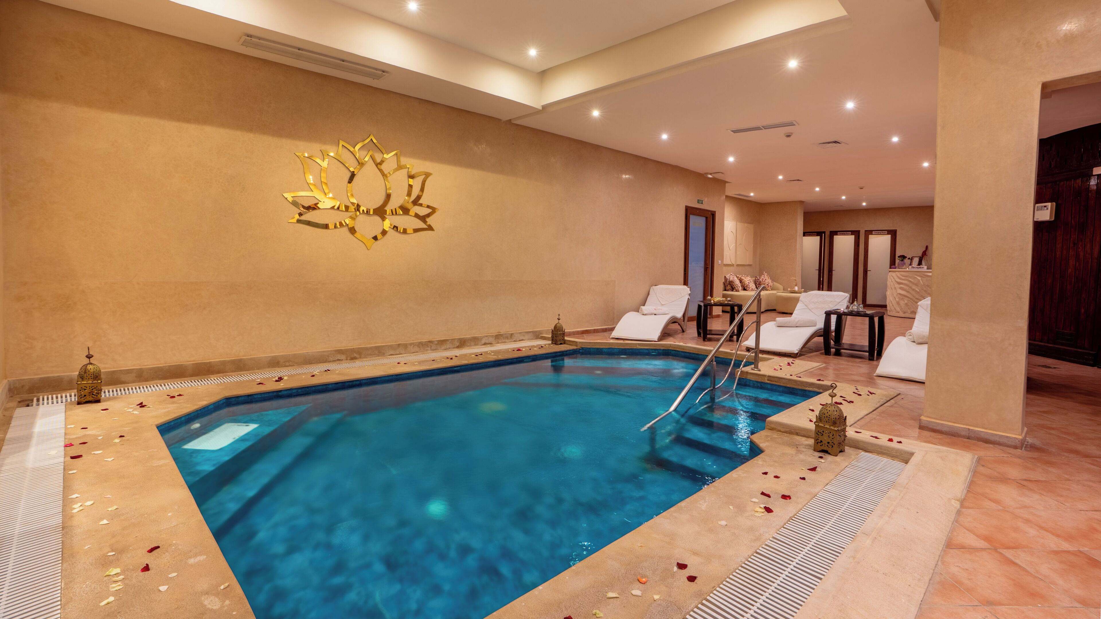 Una piscina con sillones de descanso y una pared decorativa.
